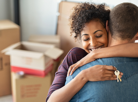 woman hugging man with keys to new home